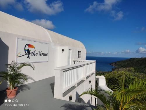 a white building with a sign that reads the karma at Spring Hotel Bequia in Port Elizabeth