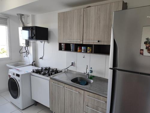 a small kitchen with a sink and a refrigerator at Areatricolor in Porto Alegre