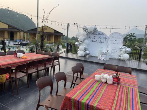 a patio with two tables and chairs and a sign at Sky Bay Lodge in Ha Giang