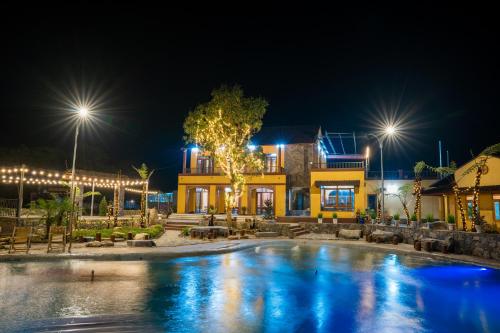 a pool in front of a building at night at Sky Bay Lodge in Ha Giang
