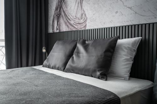 a bed with two pillows and a painting on the wall at Marrilux apartments Residence Hill in Kopaonik