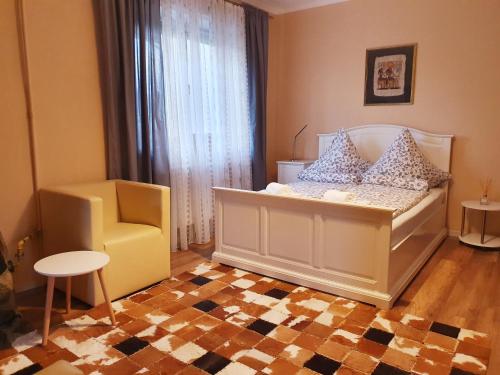1 dormitorio con 1 cama blanca y 1 silla en Studio P7, en Sibiu