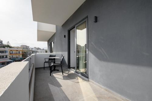 a balcony with a table and a window at EcoHeaven Suites in Amoudara Herakliou