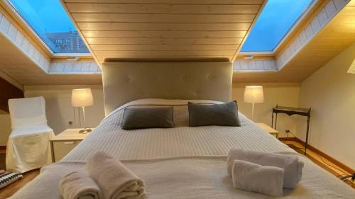 a bedroom with a large bed with a skylight at Penthouse between lake, Ouchy and city center in Lausanne