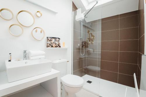 a bathroom with a toilet and a sink and a shower at Chalets et gîtes d'Orlu in Orlu