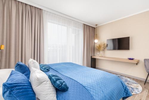 a bedroom with a blue bed and a tv at Blue Seashell Studio Bel Mare near the Beach by Renters in Międzyzdroje