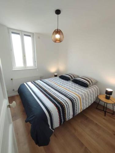 une chambre avec un lit avec une couverture rayée dans l'établissement Le Petit Jacques, appartement & garage, au Tréport