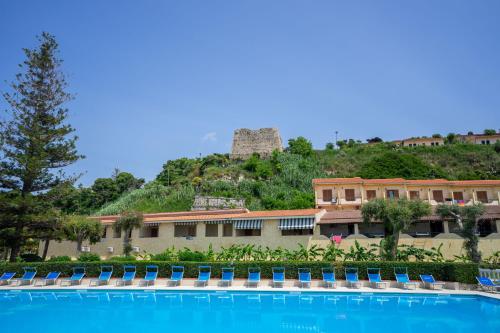 Hotel Villaggio Roller Club في كابو فاتيكانو: فندق فيه مسبح قدام جبل