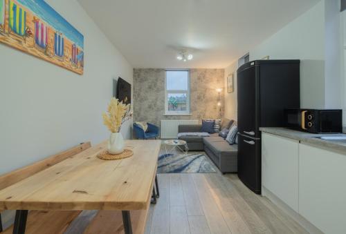 a kitchen and living room with a table and a couch at 2 Bed Garden Flat at Primal Estates Short Lets in Brighton in Brighton & Hove