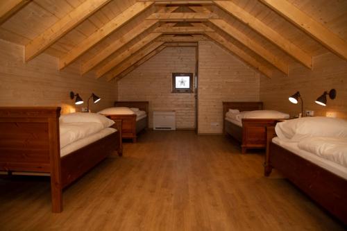a room with four beds in a room with wooden ceilings at Vinařský penzion André in Velké Pavlovice