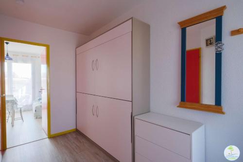 Cette chambre comprend une grande armoire blanche et une fenêtre. dans l'établissement Biscarrosse Plage -T2 classé 1 étoile 3 couchages, à Biscarrosse