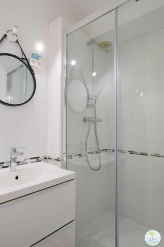 une salle de bain blanche avec une douche et un lavabo dans l'établissement Biscarrosse Plage -T2 classé 1 étoile 3 couchages, à Biscarrosse