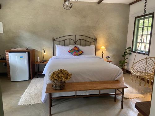 a bedroom with a large bed and a table at Matha Pousada e Bistrô in Lumiar