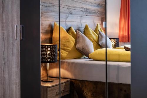 a bedroom with a bed with yellow pillows at Zillerstübchen in Schlitters