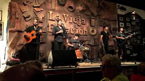 un grupo de hombres en un escenario tocando música en ANDÉN FMA-Coliving en Salta
