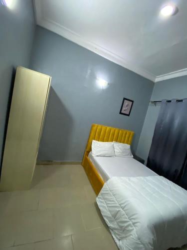 萊基的住宿－MJ Apartments，小卧室配有一张带黄色床头板的床