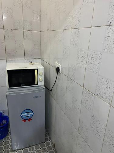 eine Mikrowelle auf einem Kühlschrank in der Unterkunft MJ Apartments in Lekki