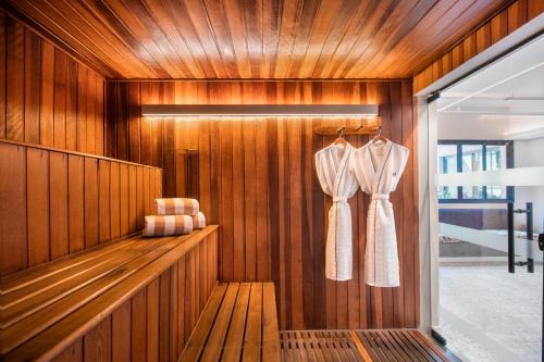 a sauna with a robe hanging on a wooden wall at Meliá Jardim Europa in São Paulo