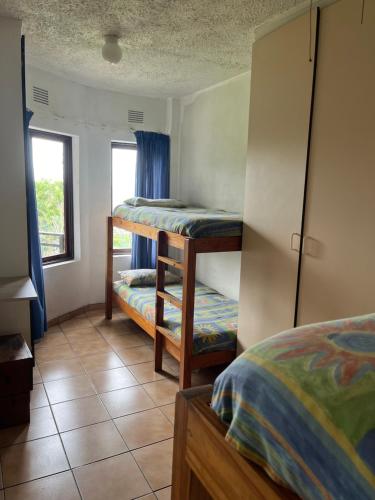a room with two bunk beds and a window at Margate Uvongo Seeskulp in Margate