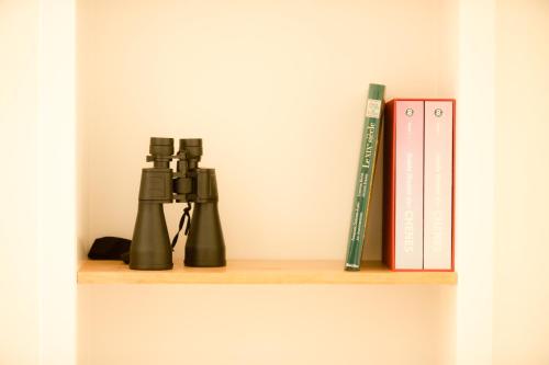 a shelf with two books and a video game controller at Gîte de Brohimont Vakantiehuis - Cottage - Exclusive Home of Silence - All in in Houyet