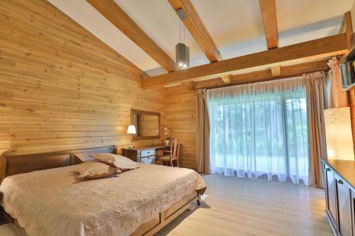 a bedroom with a bed and a wooden wall at Luxury Chalets Pirin Golf & Country Club in Bansko