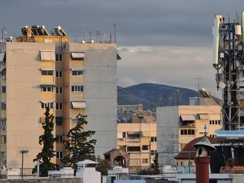 a view of a city with buildings at Sunny Home Private Jacuzzi Hydromassage, Fireplace, Acropolis & Lycabettus View, Underground Parking, 300m Metro Peristeri in Athens