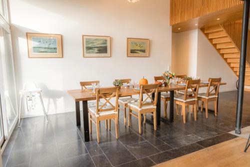 a dining room with a wooden table and chairs at Gîte de Brohimont Vakantiehuis - Cottage - Exclusive Home of Silence - All in in Houyet