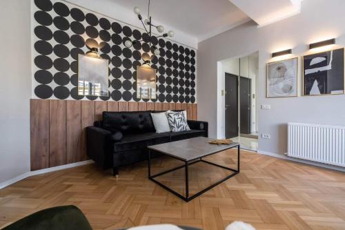 een woonkamer met een zwarte bank en een tafel bij Rigas29 - UrbanNest Bucharest in Boekarest