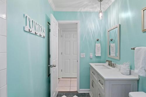 baño con lavabo blanco y paredes azules en Island House 131, en Hilton Head Island