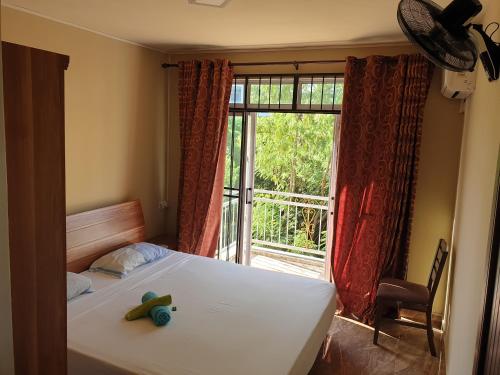 a bed with a toy on it in a room with a window at Surf House in La Gaulette
