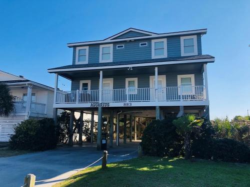 een groot huis met een balkon aan een straat bij Aquarius home in Holden Beach