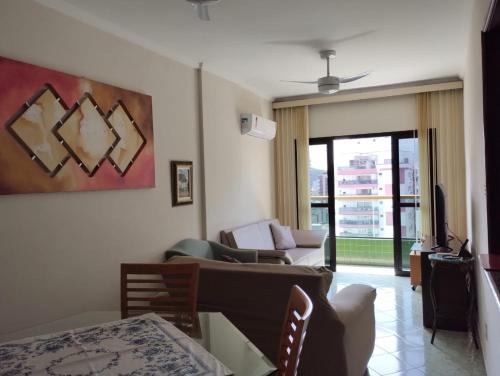 - un salon avec un canapé et une table dans l'établissement Apartamento no canto do forte, à Praia Grande