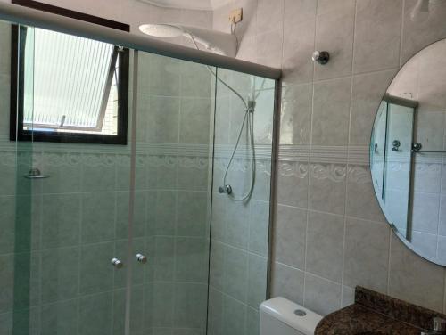 La salle de bains est pourvue d'une douche, d'un lavabo et d'un miroir. dans l'établissement Apartamento no canto do forte, à Praia Grande