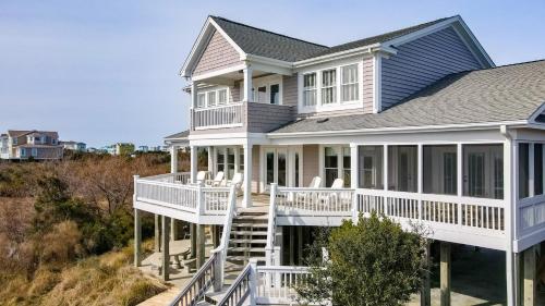 a large white house with a white deck at Cypress Hall in Holden Beach