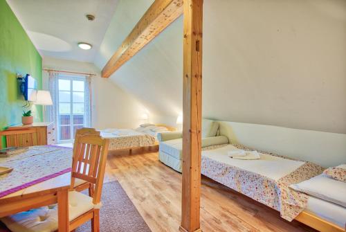a room with three beds and a table and a chair at Penzion Pivnice - Jítravský Dvorec in Rynoltice