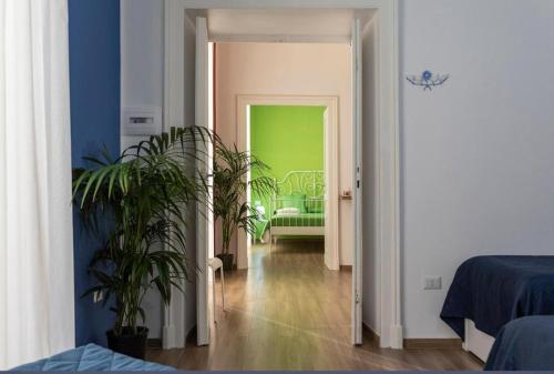 una habitación con una pared verde y un pasillo con plantas en Spaccanapoli Rooms Duomo, en Nápoles