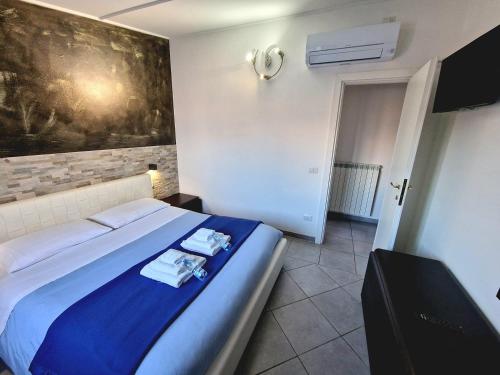 een slaapkamer met een bed met een blauwe deken bij B&B FR House Affittacamere Colleferro in Colleferro