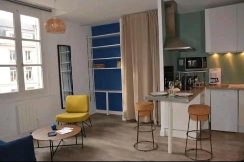 - une cuisine avec des chaises jaunes et une table dans une pièce dans l'établissement Le Foch, à Angers