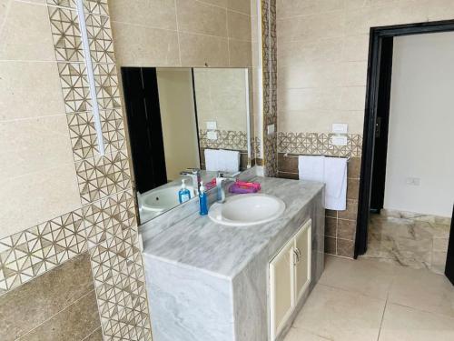 a bathroom with a sink and a mirror at Amazing Apartment Overlooking CityStars in Cairo