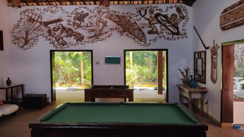 a living room with a pool table and a wall at Pousada Novo Prado in Prado