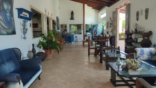 a living room with couches and tables and chairs at Pousada Novo Prado in Prado