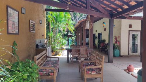 an outdoor patio with wooden benches and tables at Pousada Novo Prado in Prado
