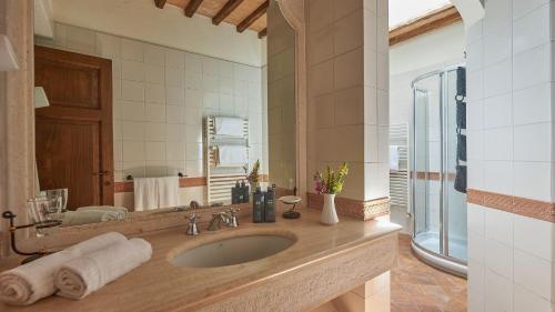 La salle de bains est pourvue d'un lavabo et d'un grand miroir. dans l'établissement Villa Boscarello 17, à Trequanda