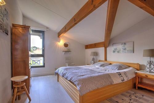 a bedroom with a large bed and a window at Biscarrosse Lac duplex 4 personnes classé 1 étoile in Biscarrosse