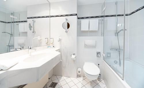 a bathroom with a sink and a toilet and a shower at Dorint Charlottenhof Halle (Saale) in Halle an der Saale
