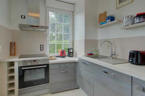 une cuisine avec un évier et une cuisinière dans l'établissement Biscarrosse classé 2 étoiles proche Latécoère, à Biscarrosse