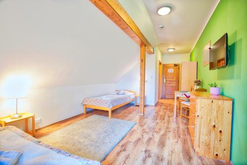 a room with a bed and a desk and a tv at Penzion Pivnice - Jítravský Dvorec in Rynoltice