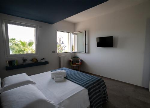 una camera con un letto e una TV e due finestre di sea&sun a Pozzallo