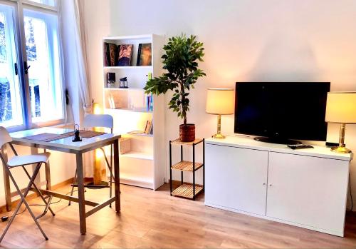 a living room with a flat screen tv on a white cabinet at BRANDNEW - Executive Apartement 1 in Bad Gastein
