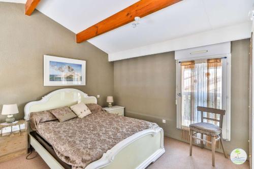 une chambre avec un lit blanc et une fenêtre dans l'établissement Biscarrosse Duplex classé 2 étoiles avec parking privatif pour 6 personnes, à Biscarrosse